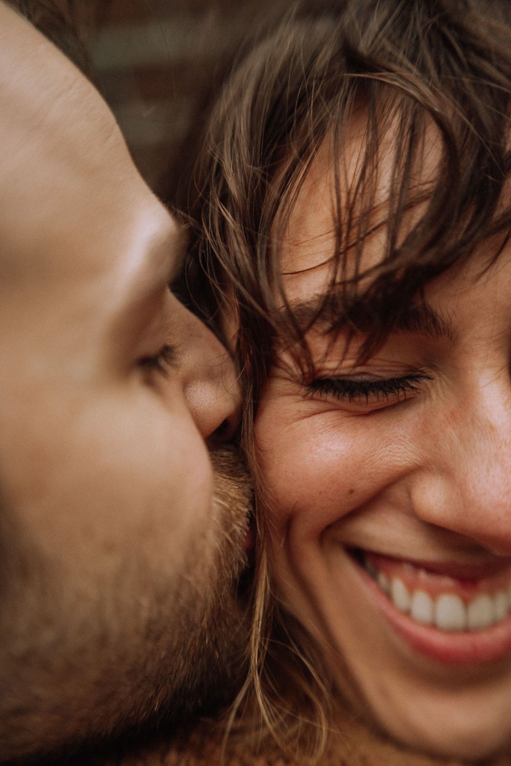 Intimate close-up portrait capturing genuine joy and affection between couple.