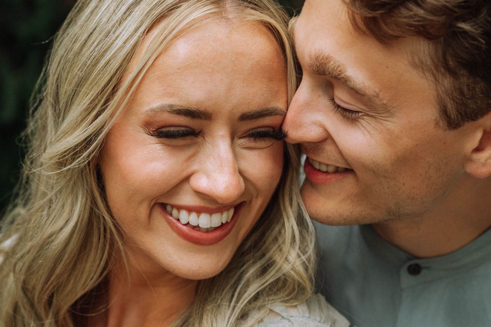 Close-up of a romantic couple sharing an intimate moment with genuine smiles and laughter.