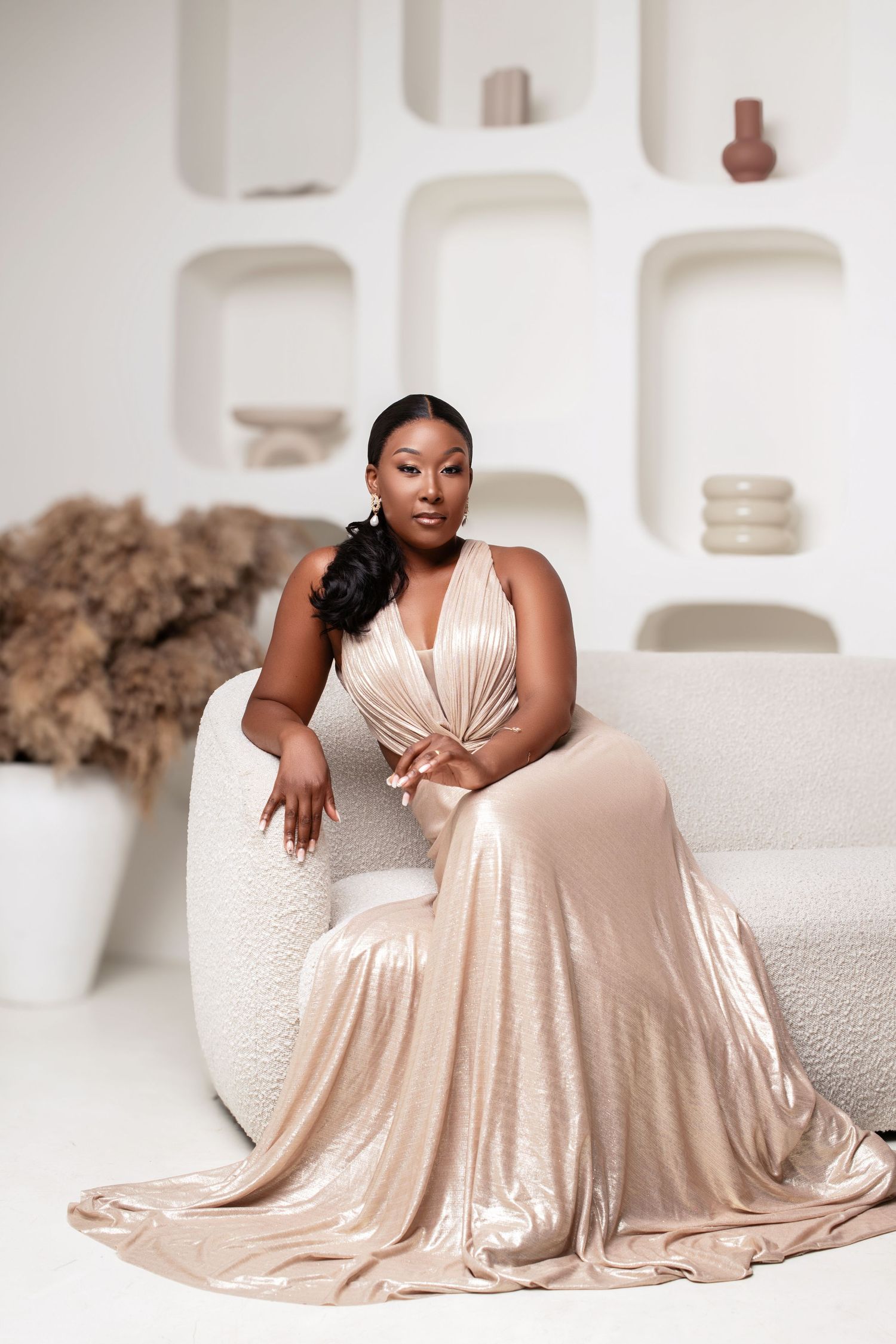A glamorous portrait in a cream dress against white architectural built-ins.
