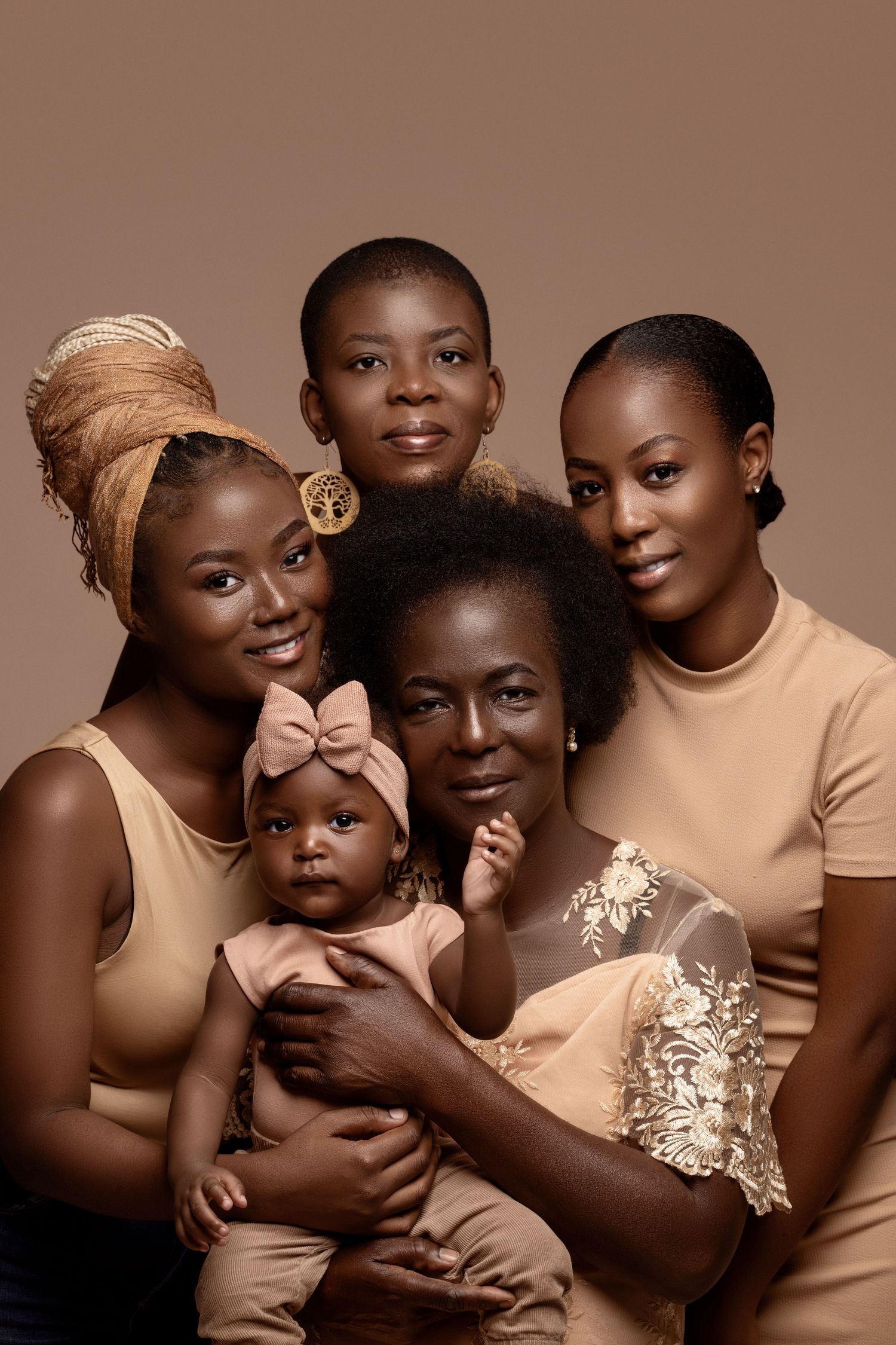 Stylish family portrait in neutral tones against brown background.