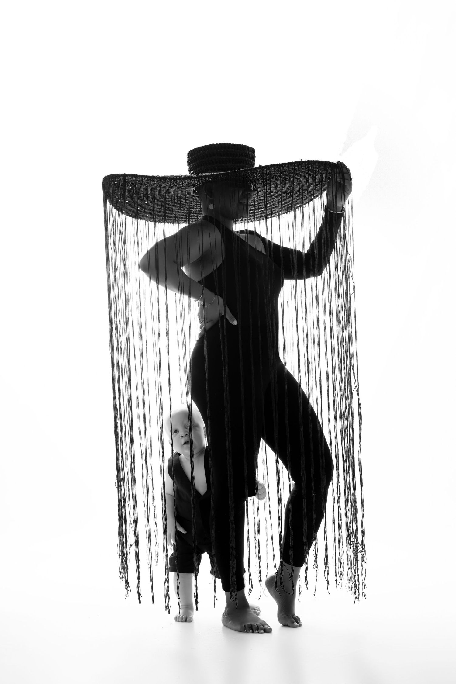 Artistic silhouette portrait with dramatic fringe hat creating striking visual effect.