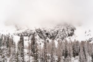 Snow-covered mountain peaks shrouded in winter fog and mist.