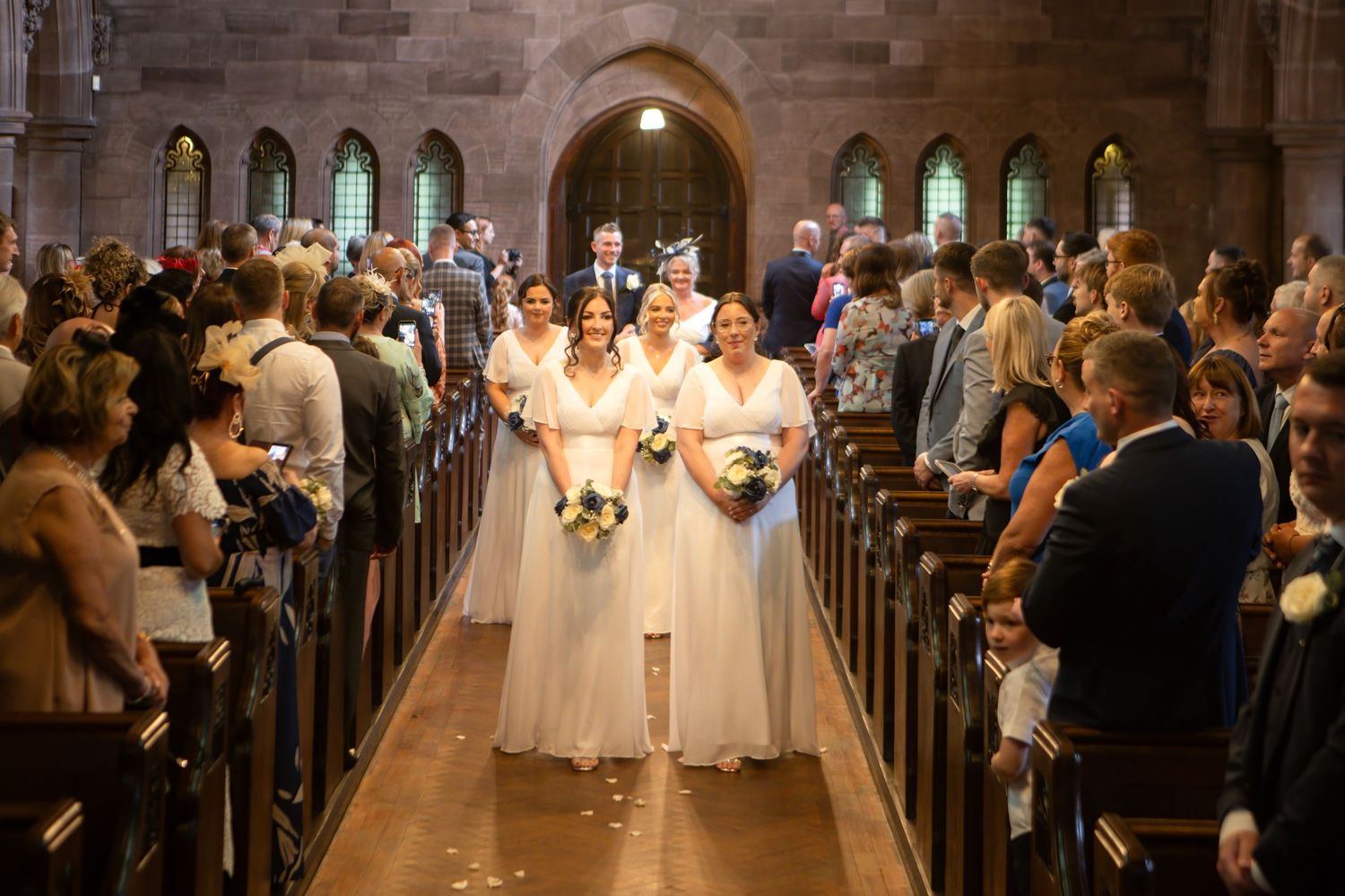 Wedding ceremony in a majestic church filled with guests and natural light.