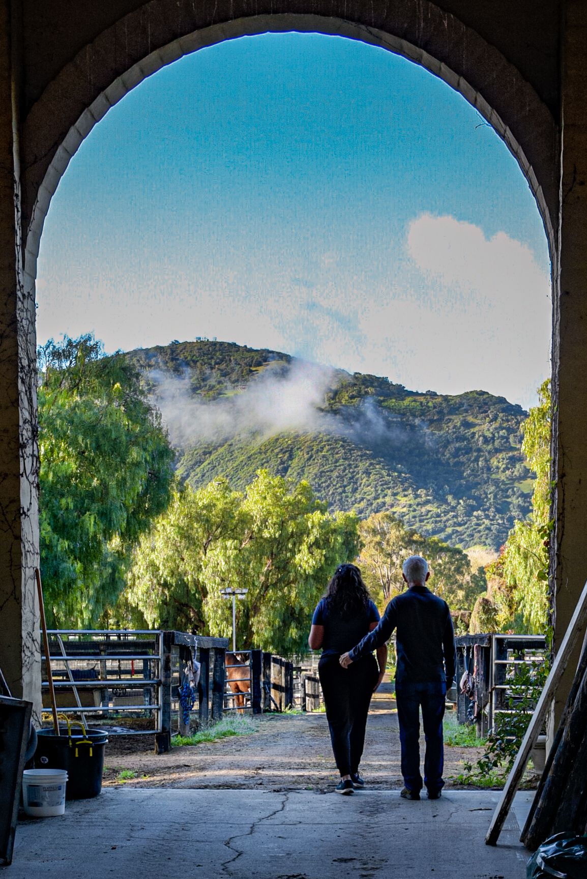 Subjects in silhouette standing in doorway of stable. #eventphotography #eventphotographer #photographer #portraitphotographer