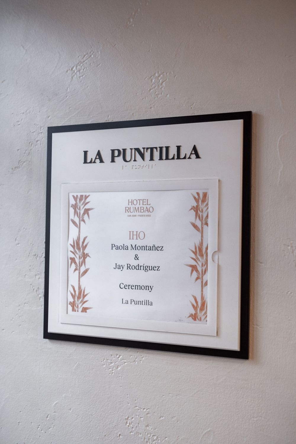 Wedding venue signage reading La Puntilla mounted on textured cream wall.