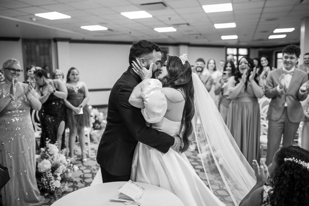 A black and white photo of a couple's first dance at their wedding reception.