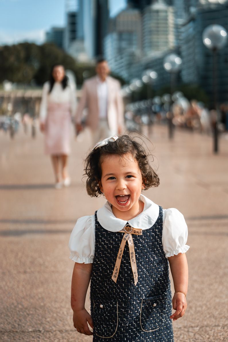 A happy child smiling at the camera during a family photoshoot in Sydney, radiating joy and excitement