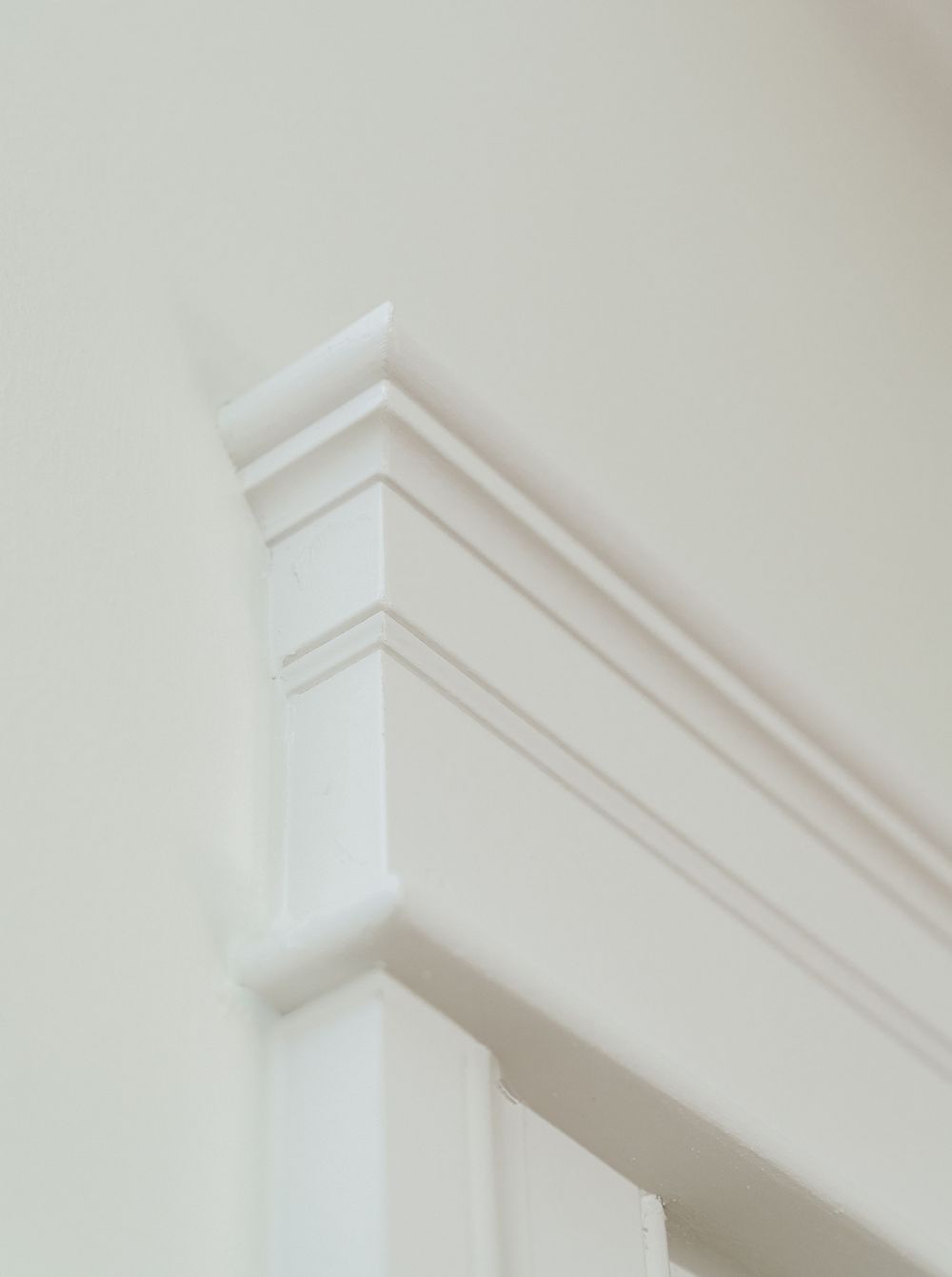 White crown molding detail at ceiling corner with elegant layered trim profile.