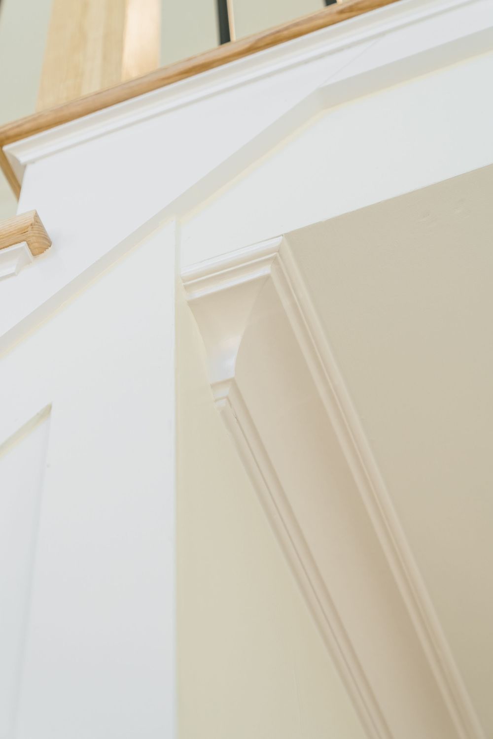 White painted interior trim and molding detail on a staircase wall with elegant architectural accents.