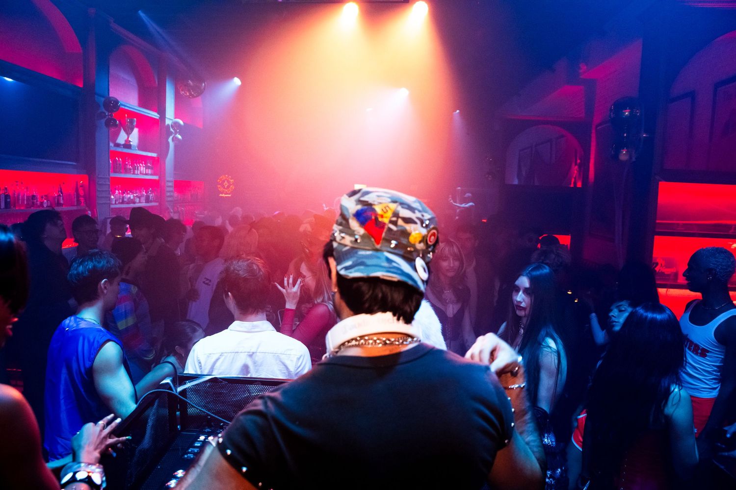 Event Photo of Slush puppy djing in front of a large crowd at Haus of Muah at the palm and pine in LA. Blue and orange concert lights shine