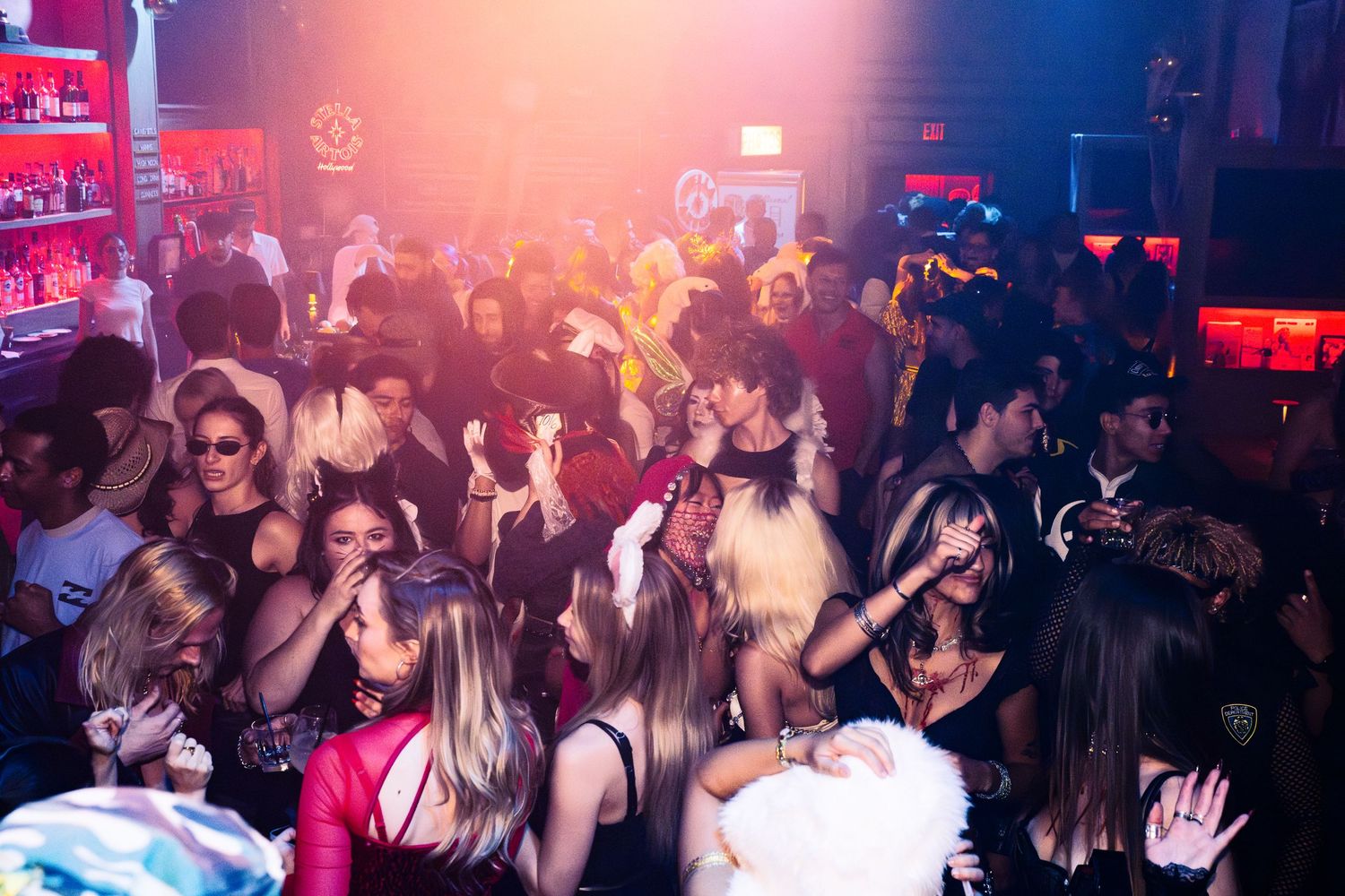 Event photo of the crowd at Haus of Muah at the palm and pine in LA. People are dancing under blue and orange lights.