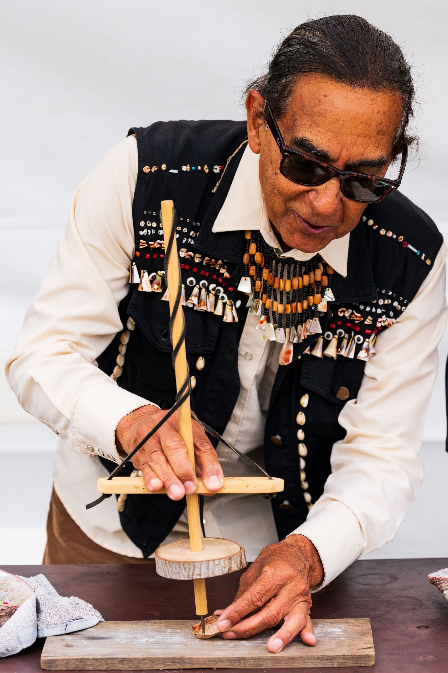 A photo of the member of the Tongva tribe demonstrating how to use one of their indigenous tools at the Friends of Ballona Migration Event