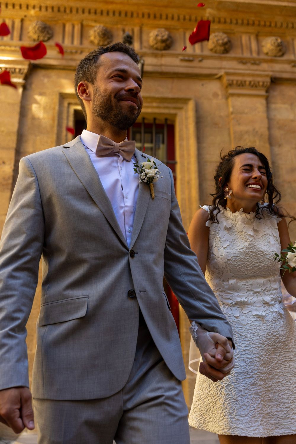 Mariés main dans la main devant un décor provençal, photographe mariage à Aix-en-Provence.