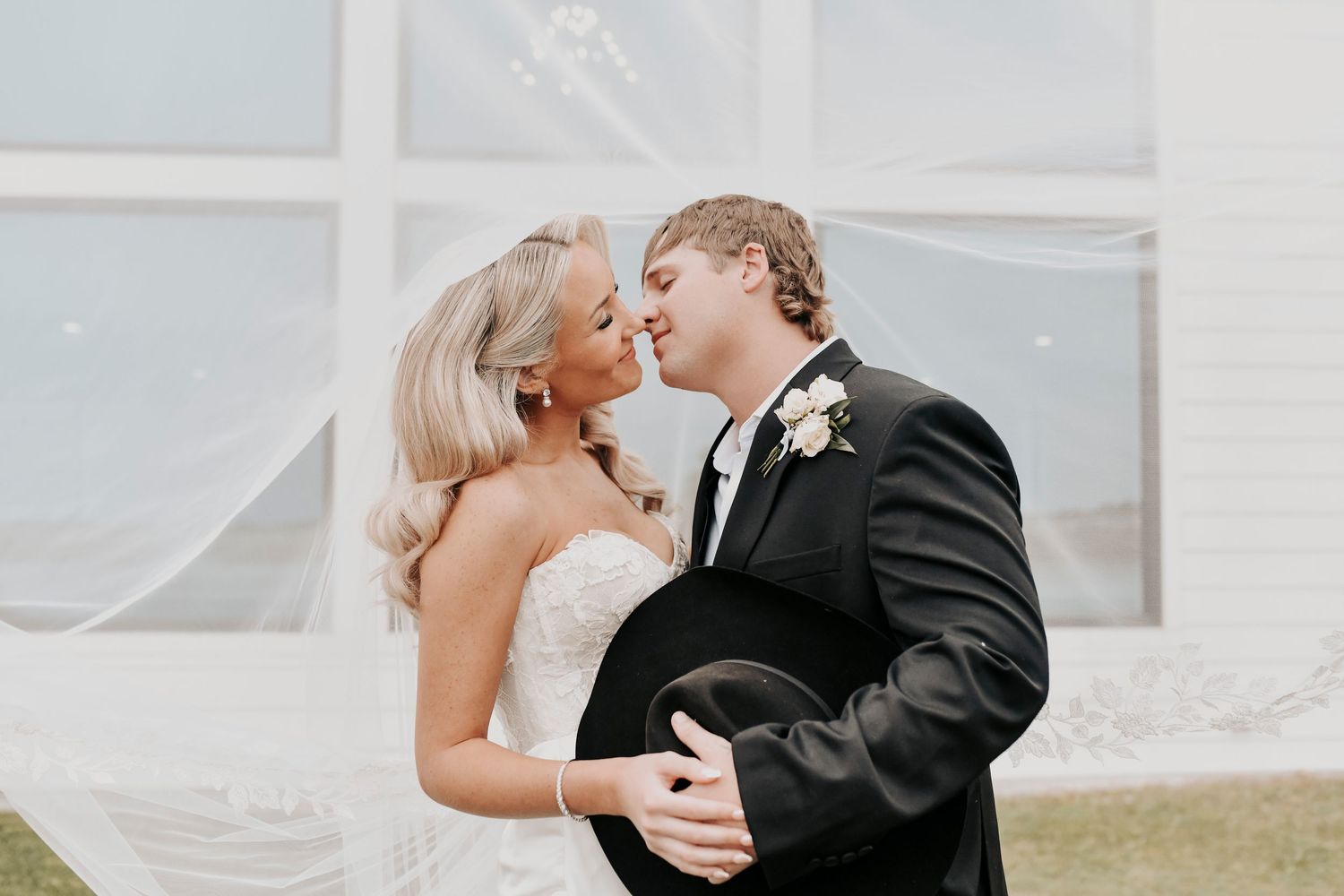 Newlyweds embracing at sunset in front of wedding chapel