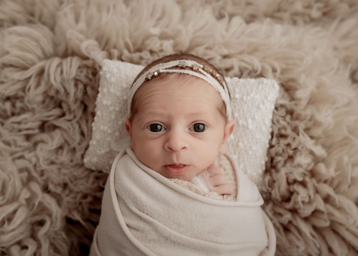 Newborn baby making eye contact during portrait session