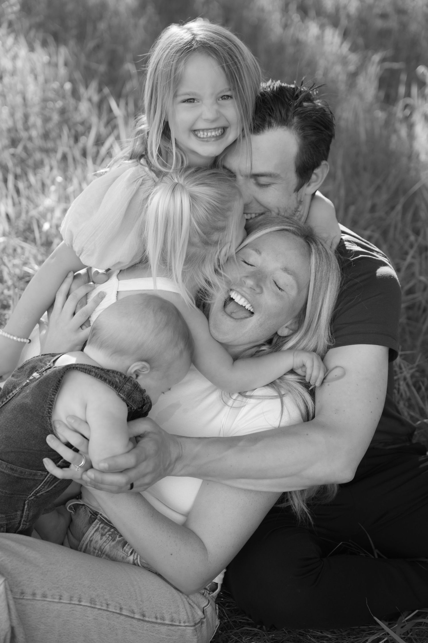 family cuddle pile during outdoor lifestyle family session in hudson wisconsin