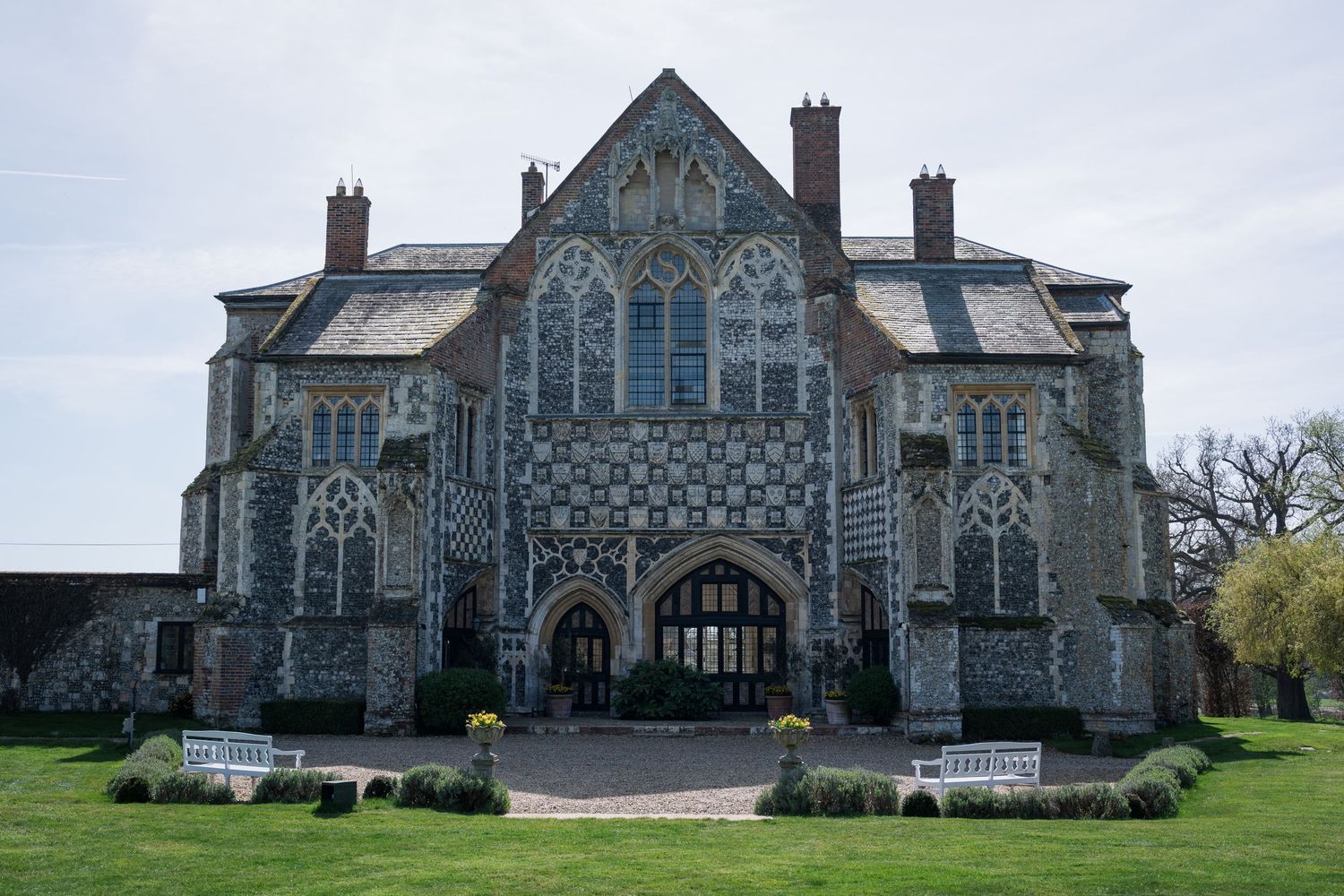 Historic Gothic stone manor house with ornate facade serves as elegant wedding venue exterior.