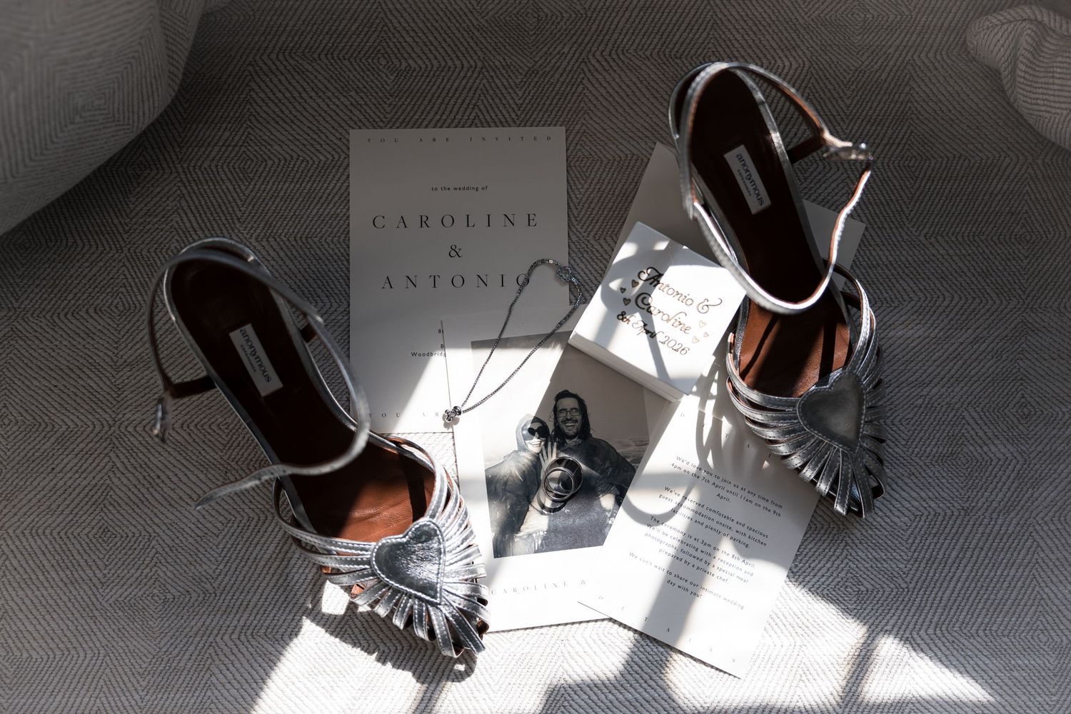 Silver metallic strappy heels beside Caroline and Antonio wedding invitation stationery.