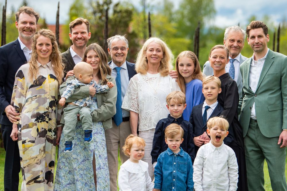 Large multigenerational family group posing together outdoors for a formal portrait photo occasion.