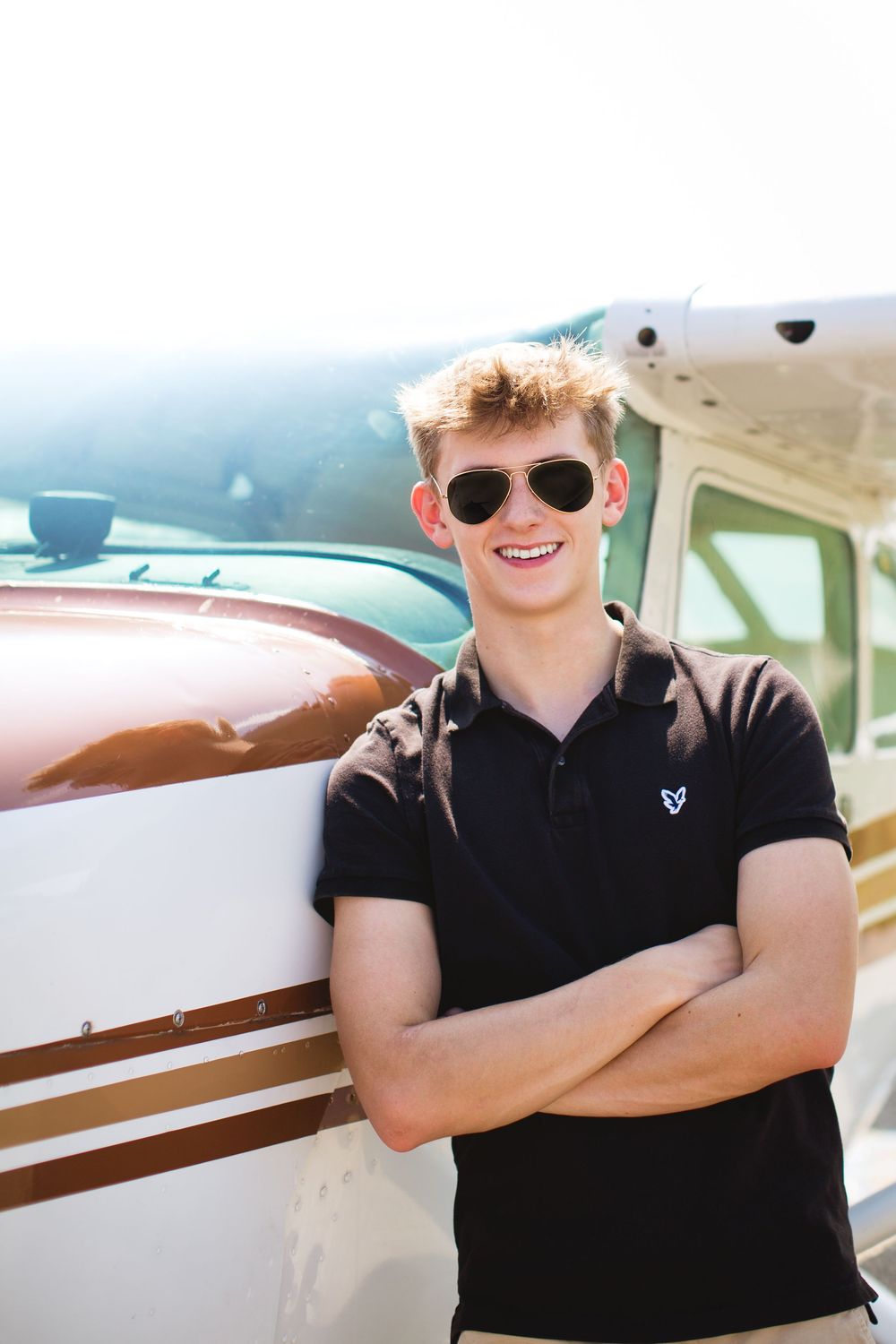 Hartland High school senior guy portrait with Cessna airplane in Howell Michigan; senior photos by Brighton, MI photographer