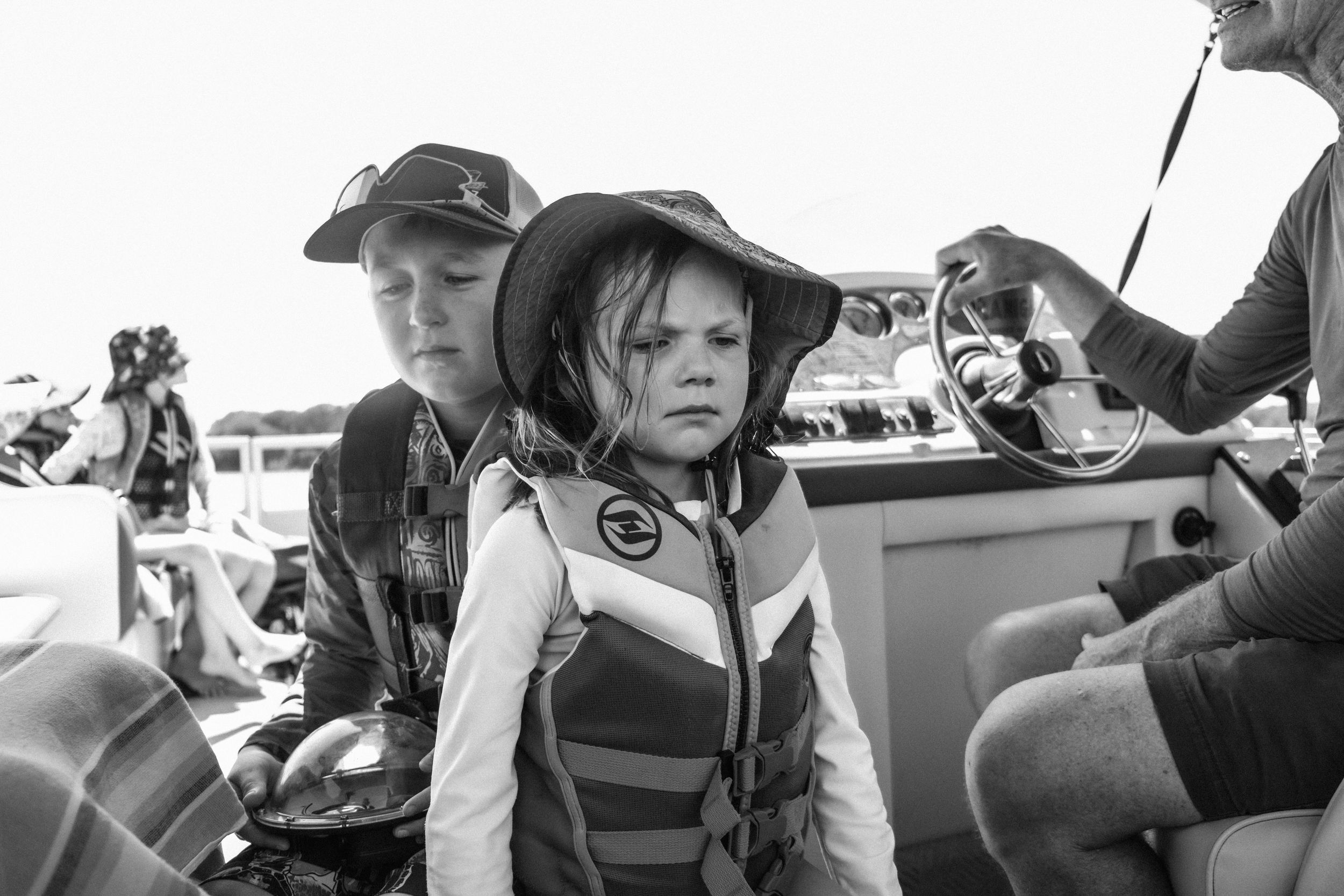 a black and white photo of two children on a boat with their grandfather on the eastern shore of virginia fishing