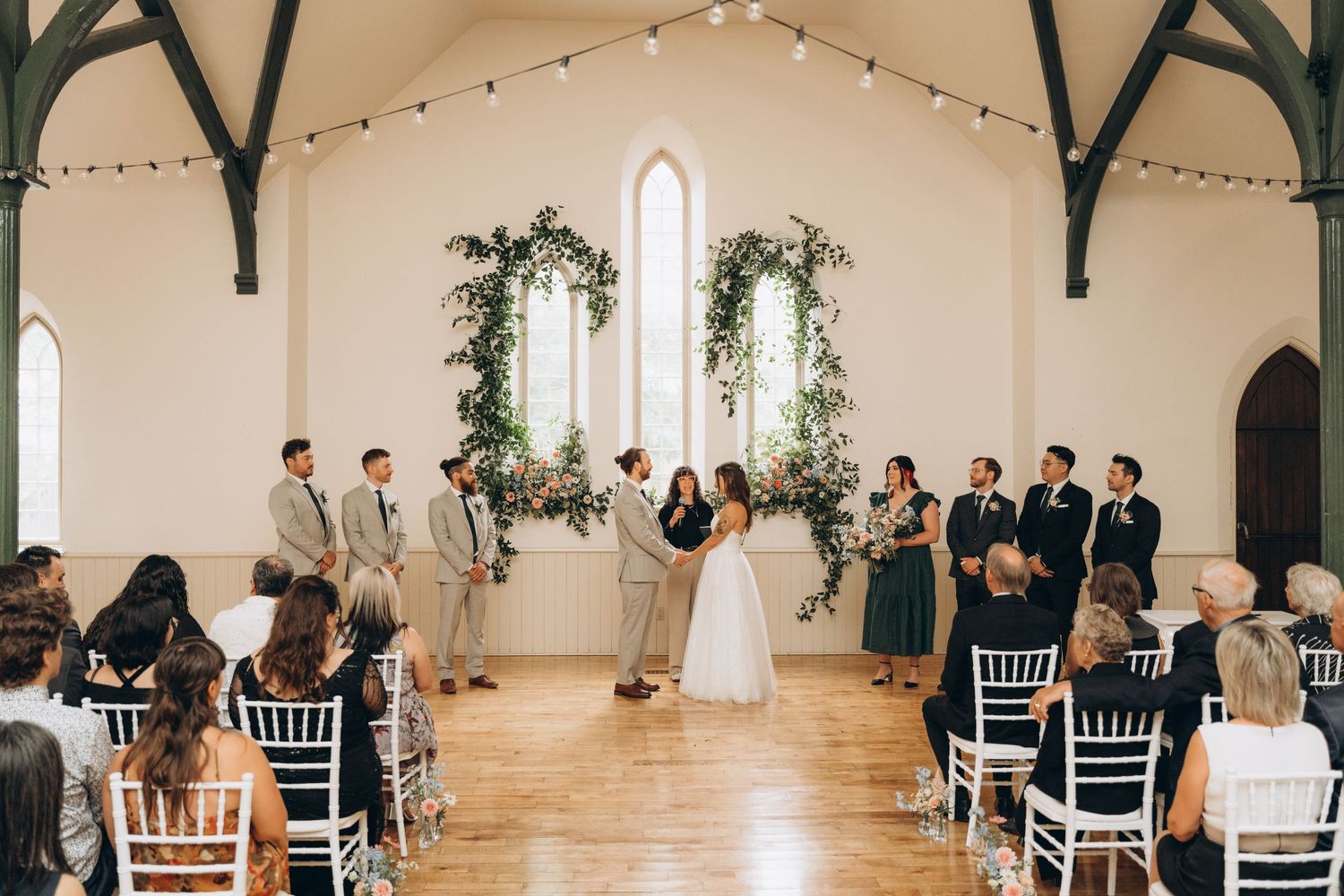 Black and white photo of a wedding ceremony in a traditional church with ornate altar decorations.