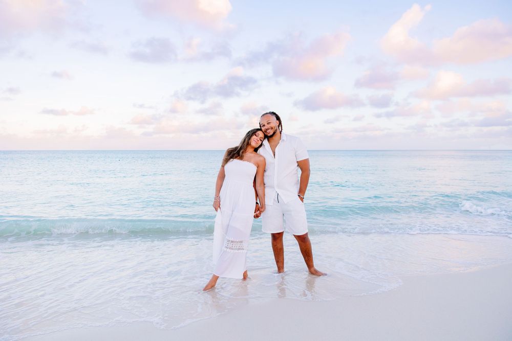 Family walking together along beach shore at sunset with waves rolling in.