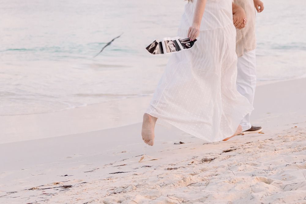 Couple strolling hand in hand on a pristine white sand beach.