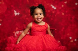 A series of photos showing a baby in a red dress against a red sparkly background.
