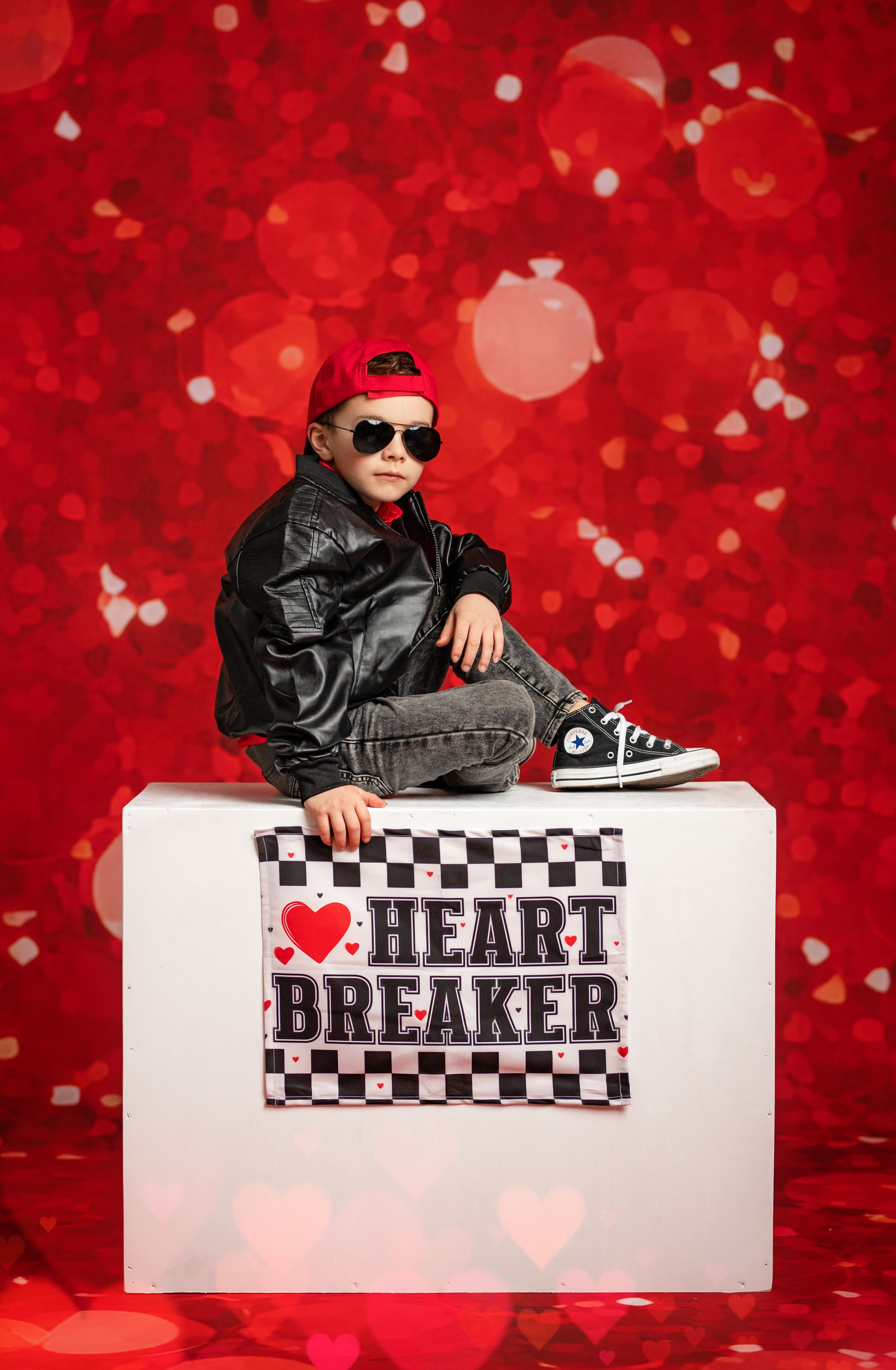 A stylish Valentine's Day photo series with checkered patterns and 'Heartbreaker' text against a red bokeh background.
