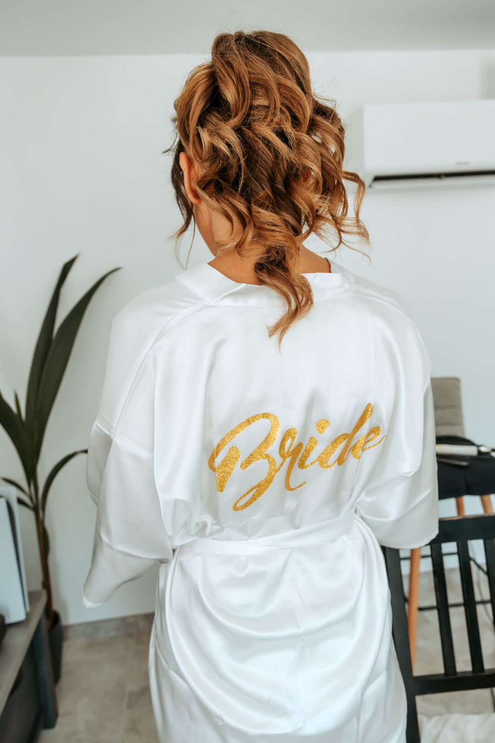 A white satin robe with gold 'Bride' text shown from behind.
