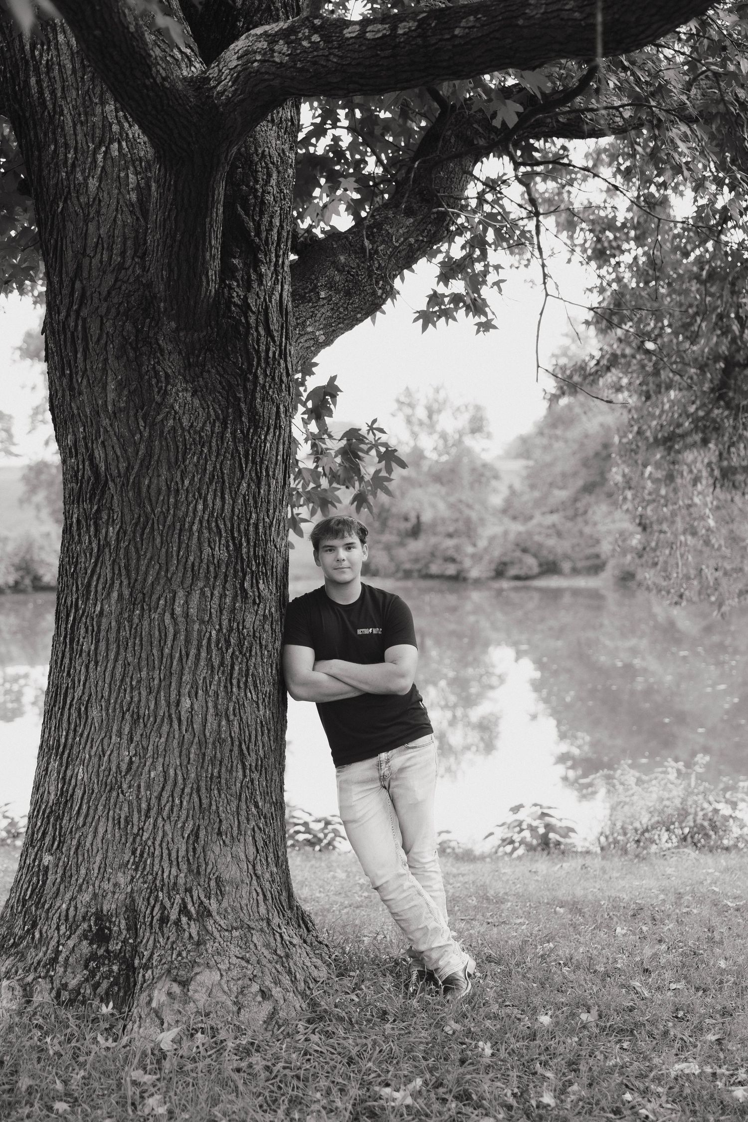 Black and white portrait series showing someone sitting against a large tree trunk in a natural outdoor setting.