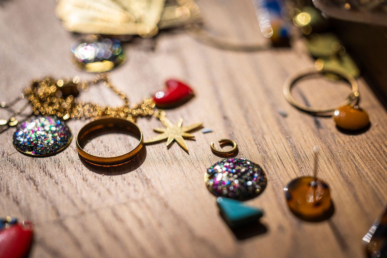 Vintage jewelry and trinkets arranged on rustic wooden surface.