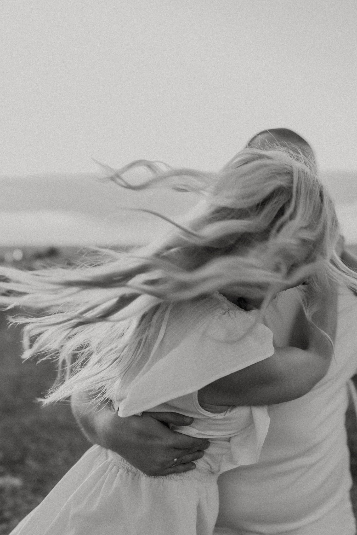 Black and white photo of a couple dancing with flowing blonde hair in the wind.