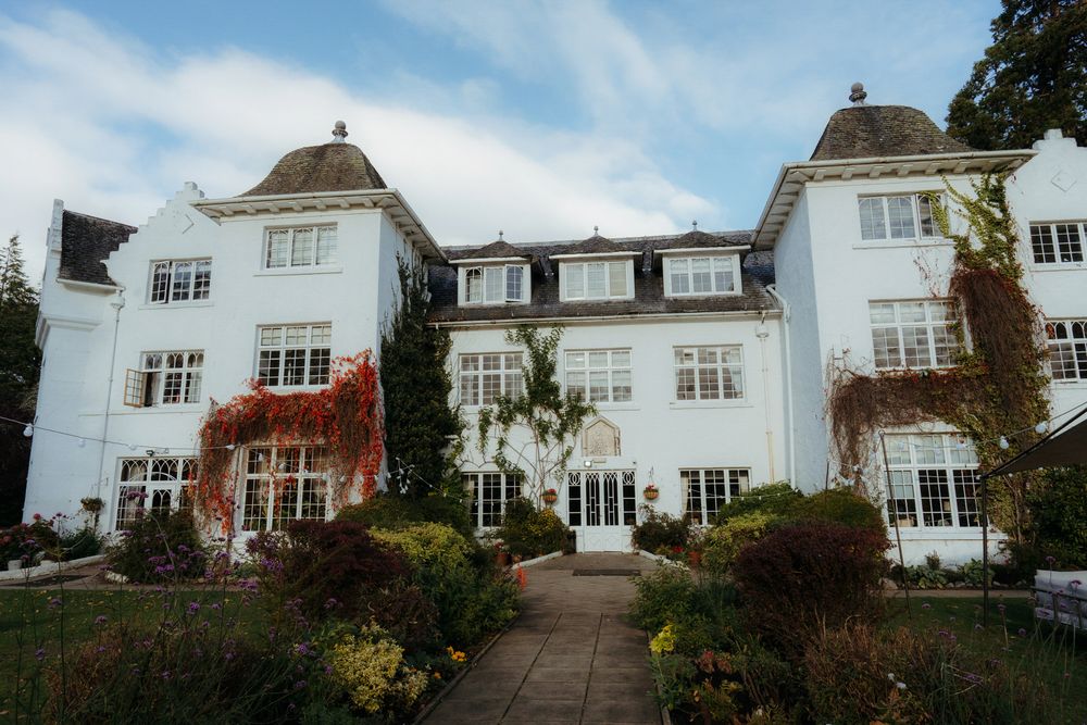 A series of white residential houses on a hillside with landscaped gardens and coastal views.