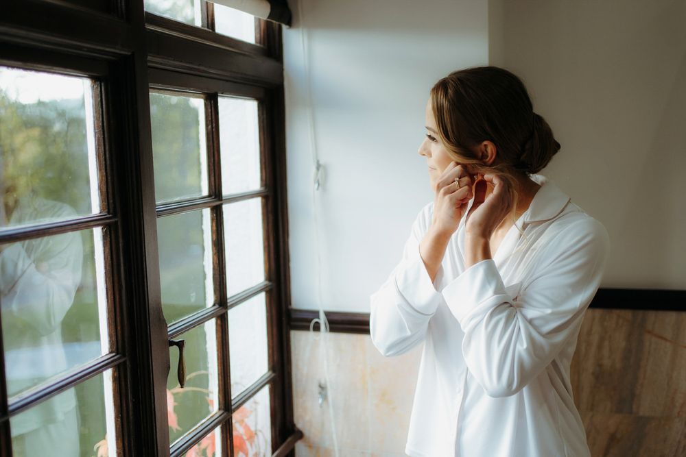 Person in white shirt stands by window in sequence of photos showing contemplative poses against natural light.