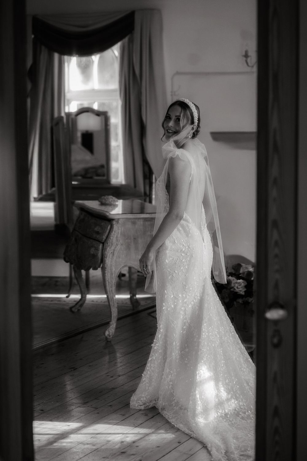 A series of black and white photos showing a bride in a sparkly wedding gown walking through sunlit hallways.