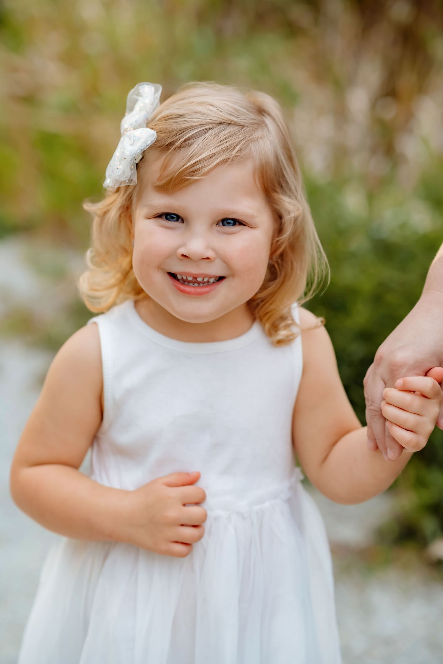 A series of close-up shots showing a small child in a white dress with a happy expression.
