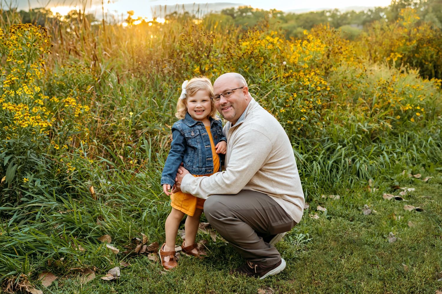 People enjoying quality time together among blooming yellow wildflowers at golden hour.