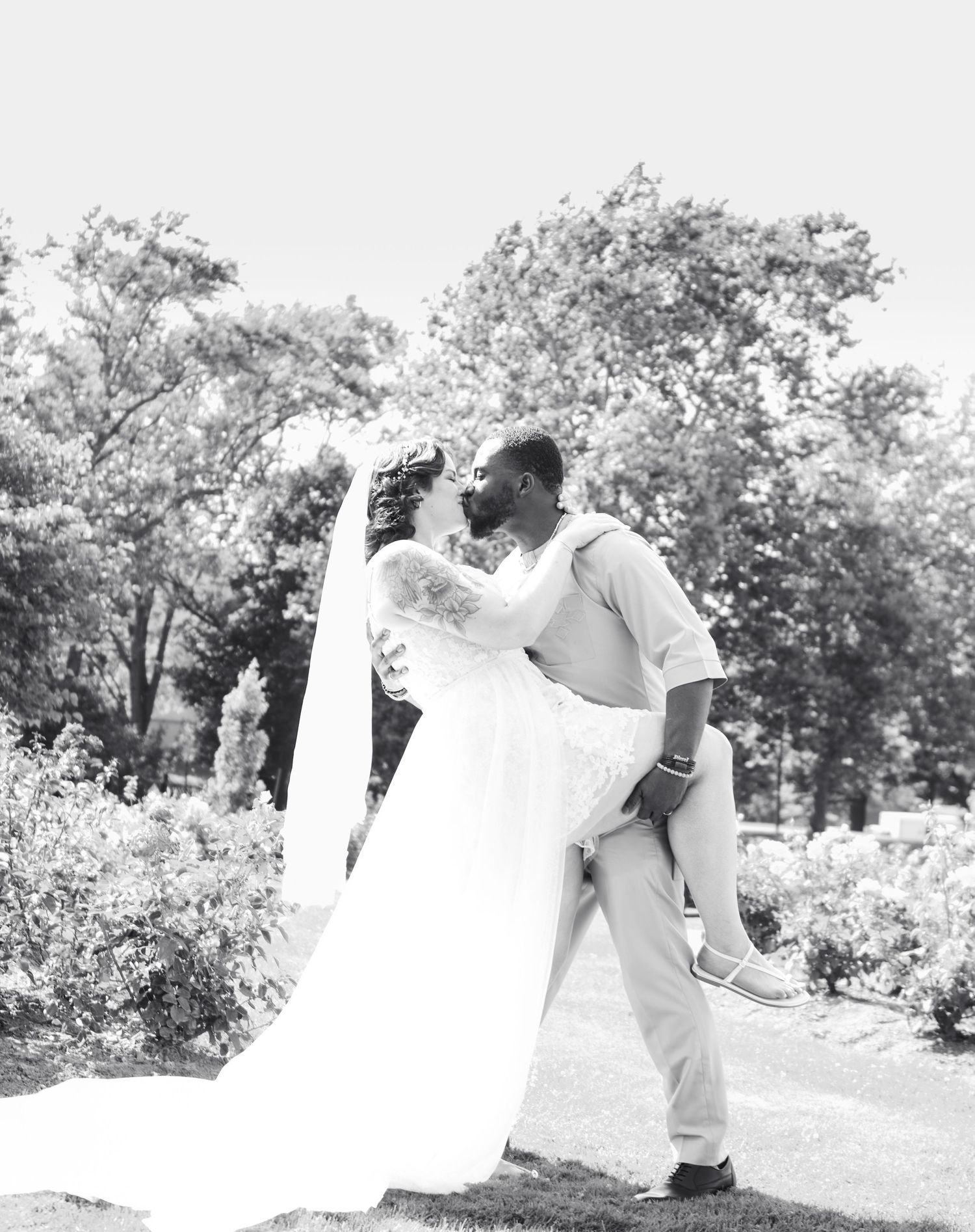 Black and white wedding photos showing playful moments in an outdoor setting.