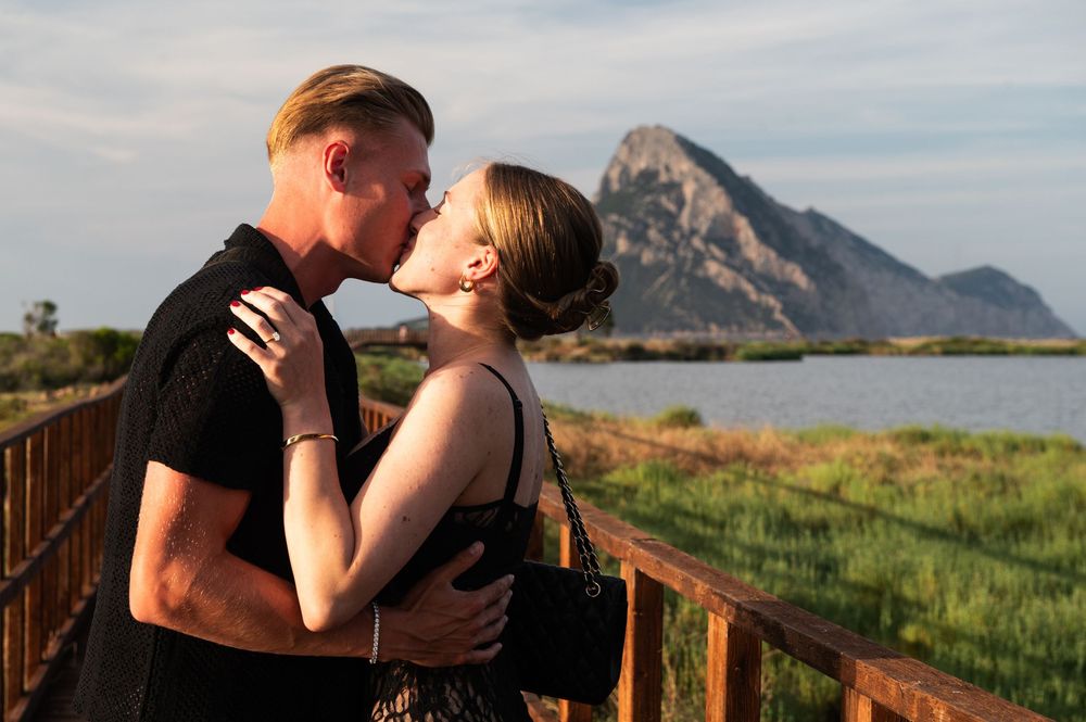 Intimate moment shared on boardwalk with mountain vista and wetlands in background.