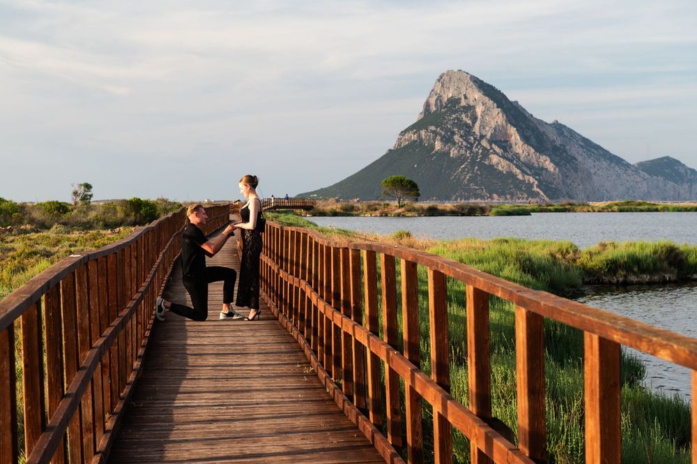 Wooden boardwalk leading to majestic mountain peak across wetland landscape.