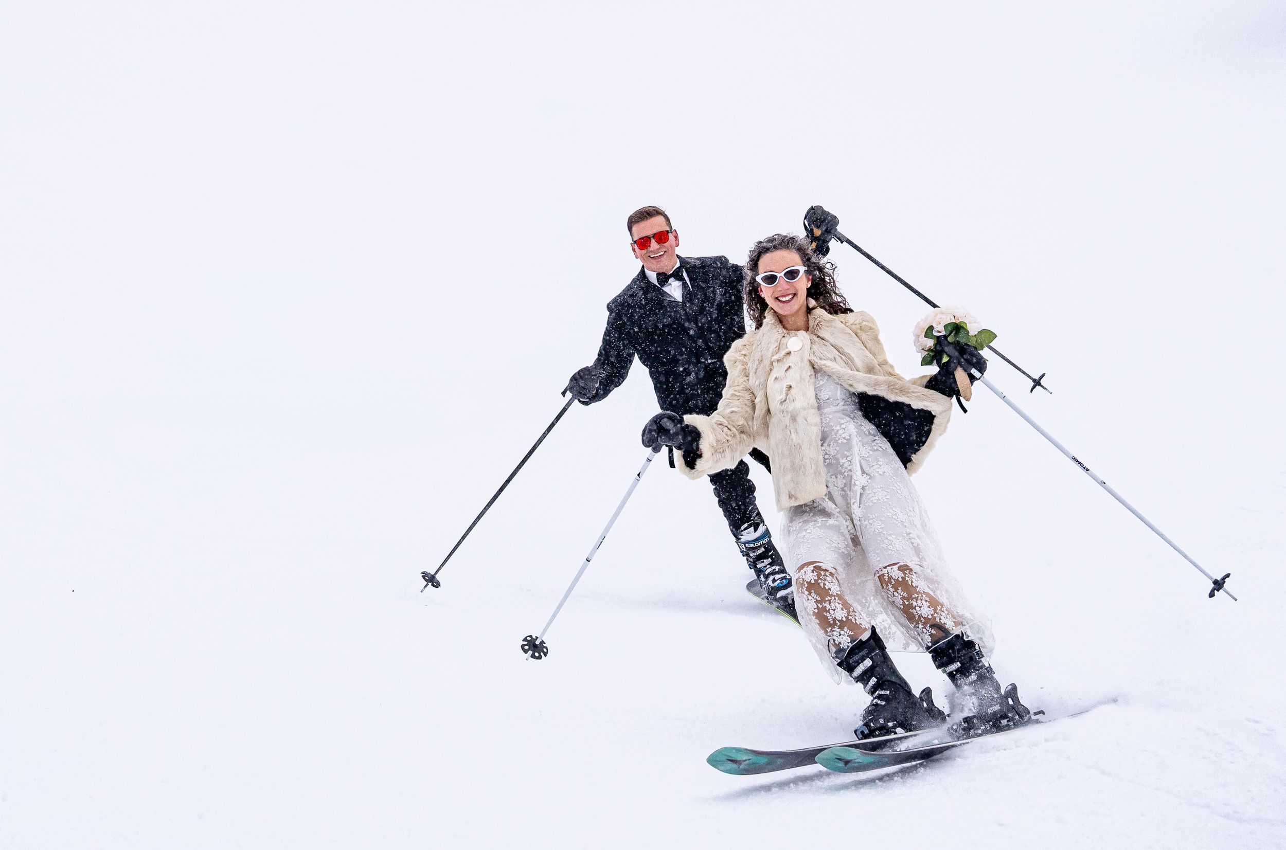 Winter wedding couple skiing together in snow — adventure wedding photography in Revelstoke.