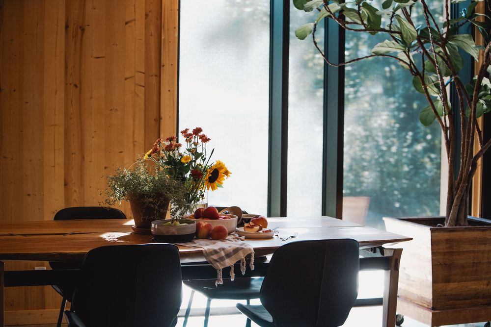 Warm dining room with natural light and floral centerpiece — professional real estate photography in Revelstoke.