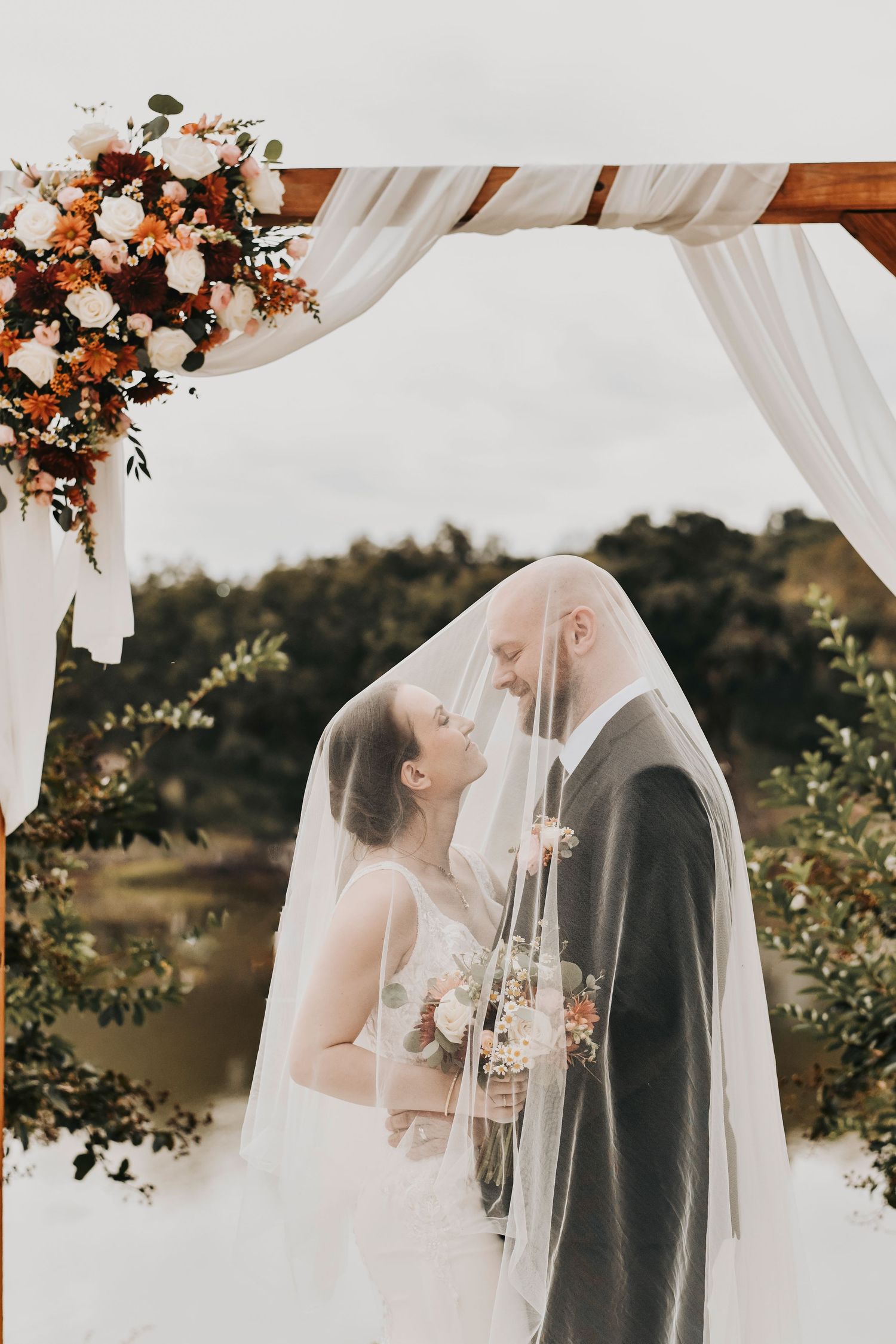 a very intimate moment between a bride and groom draped in the brides veil