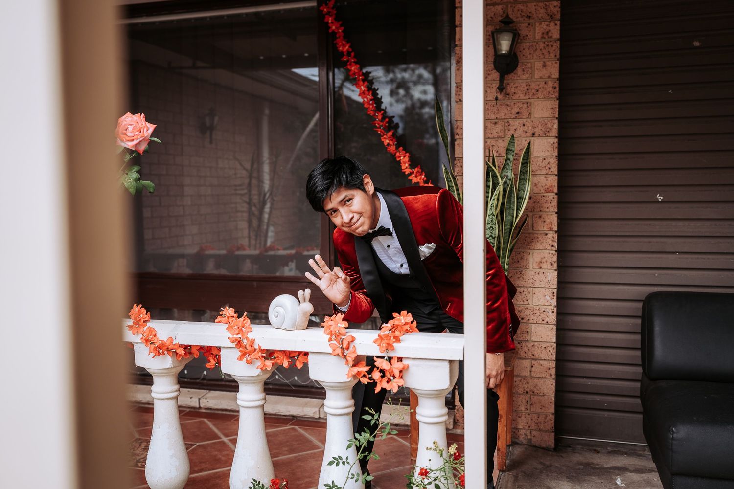 Red and white holiday decorations adorn a porch with garland and festive accents creating a cheerful winter scene.