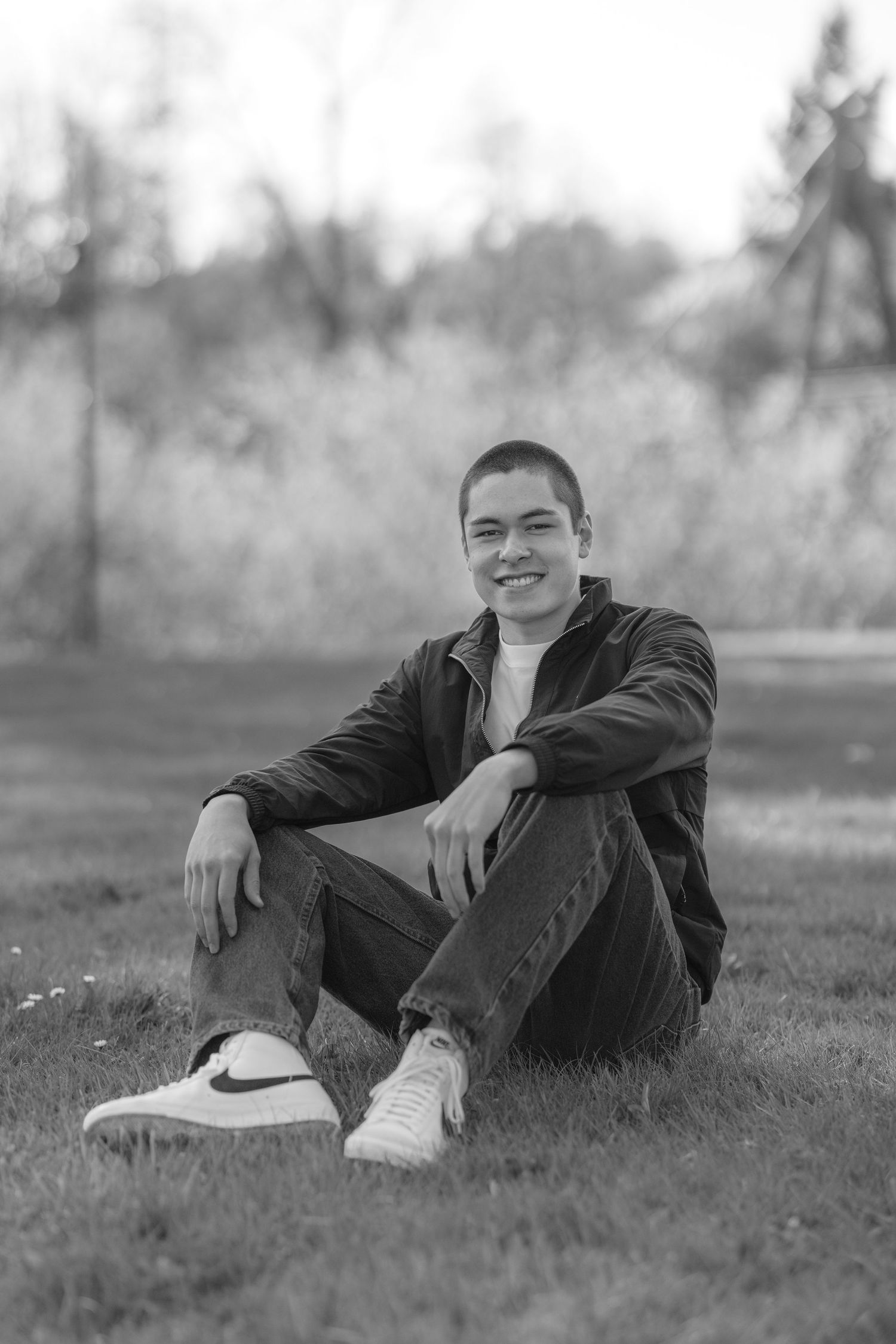 Black and white portrait series of person relaxing on grass.