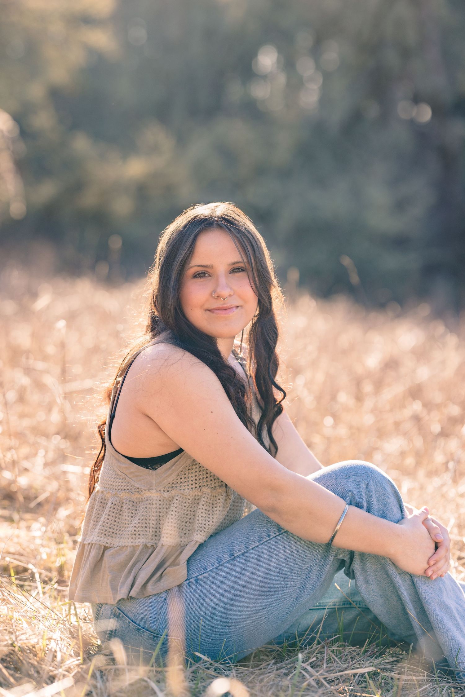 A series of outdoor portraits showing someone lying in a golden field during sunset.