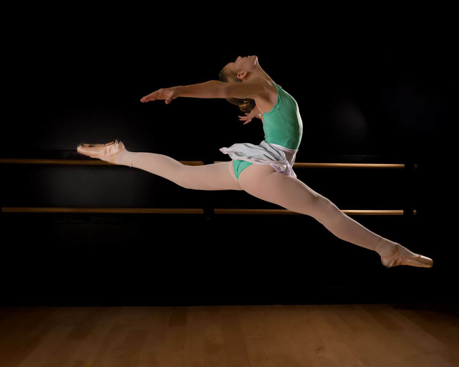 Artistic photos show gymnast performing splits and leaps in dramatic dark lighting on stage.