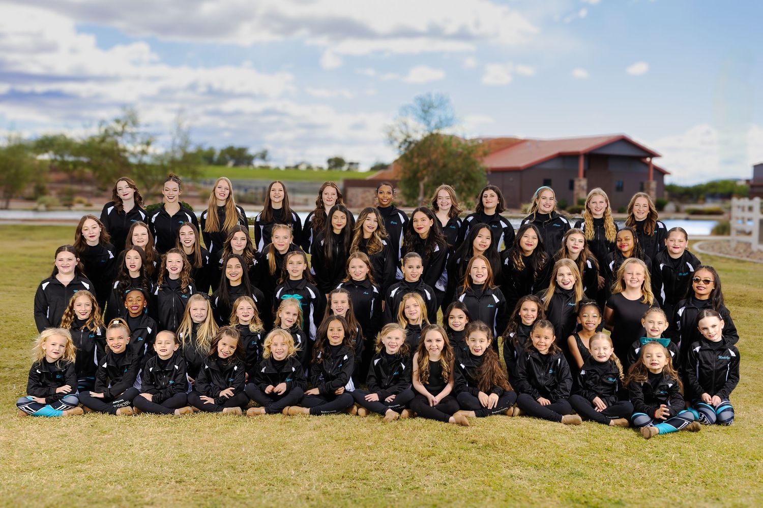 Large group wearing black outfits poses together outdoors on grass in coordinated panoramic shots.